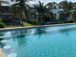 a swimming pool in front of a house with palm trees at F&F Poolvilla Beach Tha Chana in Suratthani