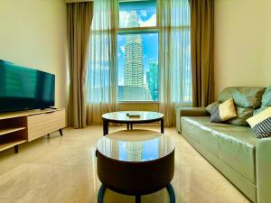 a living room with a couch and a large window at vortex suites klcc by park view in Kuala Lumpur