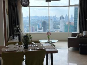 a living room with a table and a large window at vortex suites klcc by park view in Kuala Lumpur