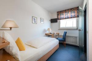 a hotel room with a bed and a desk and a window at Hotel Restaurant Esser in Wegberg