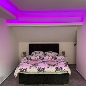 a bedroom with a bed with purple lights on it at Villa Ronić in Soko Banja