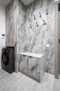 a bathroom with a washing machine and a marble wall at Plovdiv Luxury 1BR * Free Parking * Rowing Base in Plovdiv