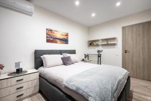 a bedroom with a large bed and a wooden cabinet at Plovdiv Luxury 1BR * Free Parking * Rowing Base in Plovdiv