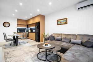 a living room with a couch and tables and a kitchen at Plovdiv Luxury 1BR * Free Parking * Rowing Base in Plovdiv