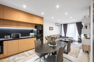 a kitchen and living room with a table and a couch at Plovdiv Luxury 1BR * Free Parking * Rowing Base in Plovdiv +14 photos