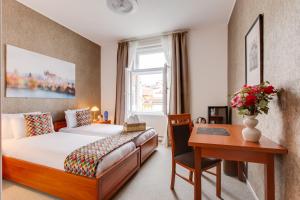 a hotel room with a bed and a desk at Kafka Prague rooms in Prague
