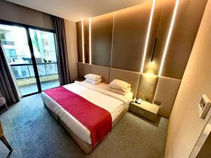 a hotel room with a bed with a red blanket at Rawsheh Boutique Hotel in Beirut