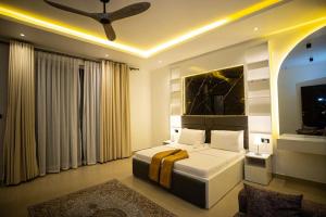 a bedroom with a bed and a ceiling fan at Zanziluxe Residences in Zanzibar City
