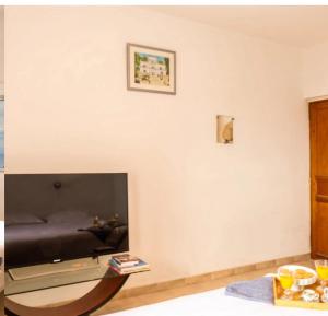 a living room with a large flat screen tv on a wall at Villa Emmanuella in Centuri