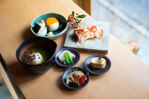 a table topped with bowls of food on a table at 宿 ロイノハコ in Gotsu