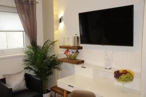 a living room with a television on a wall at Pension Dietrich in Dobel