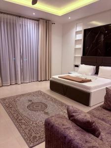 a bedroom with a large bed and a couch at Zanziluxe Residences in Zanzibar City +3 photos