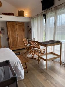 a bedroom with a bed and a table and chairs at O'Manava Lodge & Bien-Etre in Virac