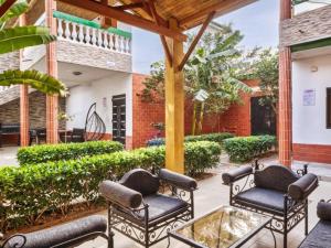 a patio with black chairs and a table at Tekrour- La case des hotes -Chambre lumineuse proche plage in Mbour
