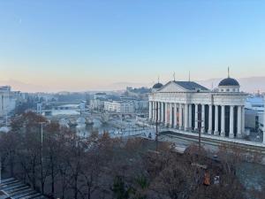 a view of a city with a river and a building at Main Square APT with Stone Bridge & Old Bazaar View in Skopje