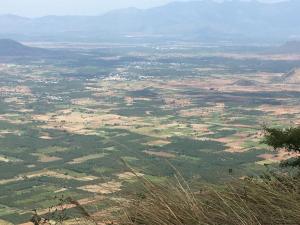 an aerial view of a field with mountains in the background at Fogveilhomestay in Idukki
