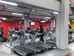 a woman walking on a treadmill in a gym at Tekrour- La case des hotes -Chambre lumineuse proche plage in Mbour