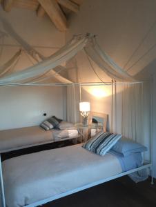 two beds in a bedroom with a canopy at Villa Babsy con piscina privata in San Teodoro