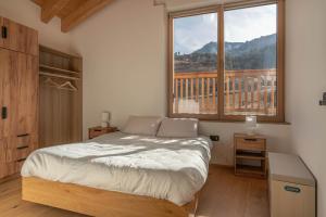 a bedroom with a bed and a large window at Duplex Cermis in Cavalese