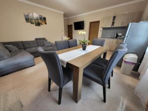 a living room with a wooden table and chairs at Li-Vi Apartman Debrecen in Debrecen
