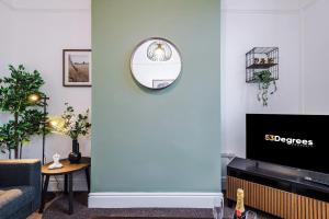 a living room with a blue wall with a mirror at Spacious 4 Bed Home in Crewe by 53 Degrees Property! Perfect for Groups & Families in Crewe