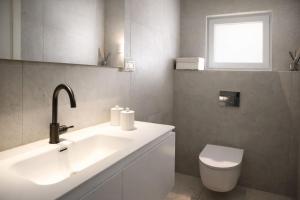 a bathroom with a sink and a toilet and a window at Merian Eilat in Eilat