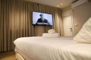a hotel room with a bed and a flat screen tv at Merian Eilat in Eilat