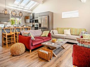 a living room with red furniture and a kitchen at 3 Bed in Brecon oc-92341 in Brecon