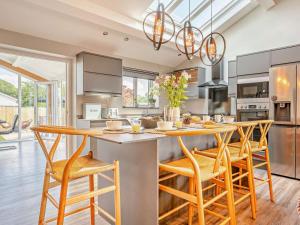 a kitchen with a large island with wooden chairs at 3 Bed in Brecon oc-92341 in Brecon +24 photos