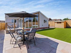 a patio with an umbrella and a table and chairs at 3 Bed in Brecon oc-92341 in Brecon