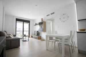 a kitchen and living room with a white table and chairs at AL045 Pinada Beach III La Mata in La Mata