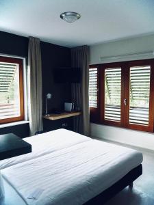 a bedroom with a large white bed and windows at Boshotel Overberg in Overberg +34 photos
