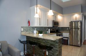 a kitchen with white cabinets and a stone counter top at New York private room 29 in West New York +14 photos