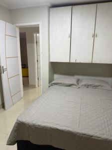 a bedroom with a large bed with white cabinets at Apartamento de Denise in Aracaju
