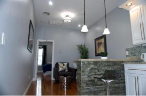 a living room with a stone fireplace and pendant lights at New York private room 29 in West New York