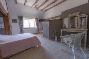 a bedroom with a bed and a table and a fireplace at La Maison Rouziès in La Bastide-lʼÉvêque +11 photos