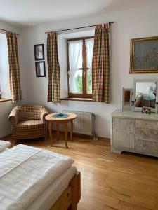 a bedroom with a bed and a table and a window at Appartements am Schlossberg in Starnberg