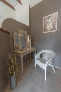 a room with a desk with a mirror and a chair at La Maison Rouziès in La Bastide-lʼÉvêque