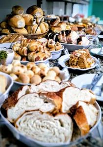 a table full of different types of pastries and pies at Villa Maior Hotel in São Roque