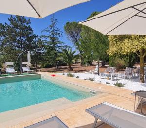 ein Schwimmbecken mit einem Tisch und einem Sonnenschirm in der Unterkunft Villa Morea-Relax in piscina in Putignano