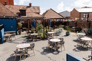 a patio with tables and chairs in a courtyard at The Railway Hotel Worthing in Worthing