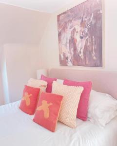 a bed with colorful pillows on it with a painting at The Lodge in Kelso +19 photos