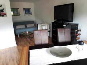 a living room with a tv and a table and chairs at FeWo Edelweiß Jäger in Nesselwang