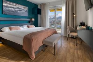 a hotel room with a large bed and a desk at Alp Art Hotel Monthey in Collombey +42 photos