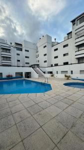 a large building with a swimming pool in front of it at Residence Punta del Este 107 in Punta del Este