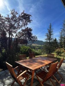 a wooden table with four chairs and a view at Chambre d'hôte domainedesthermesgap in La Celle-sous-Gouzon