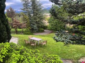a table and chairs in the grass in a garden at Chambre d'hôte domainedesthermesgap in La Celle-sous-Gouzon