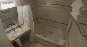 a bathroom with a tub and a sink and a bath tub at Alma Andina Hosteria in Villa La Angostura