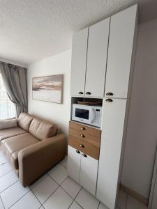 a living room with a couch and a microwave at Residence Punta del Este 107 in Punta del Este