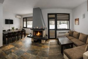 a living room with a fireplace and a dining room at Марковската къща in Oreshak